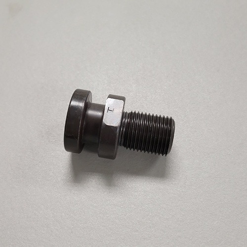A metal assembly consisting of a large bolt, two washers, and a black rubber element, possibly a vibration damper, on a grey surface.