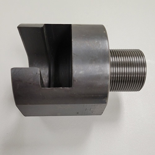 A specialized metal tool with a threaded shaft and a slotted end, designed for a mechanical application, on a grey background.