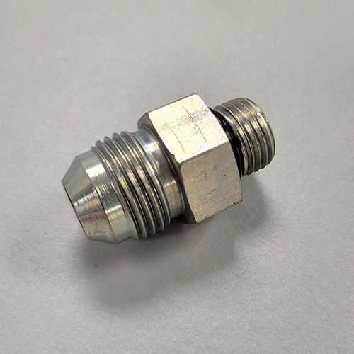 A hydraulic fitting with male threads on both ends and a hexagonal nut in the middle, made of metal, on a white surface.