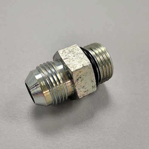 A hydraulic fitting with male threads on both ends and a hexagonal nut in the middle, made of metal, on a white surface.