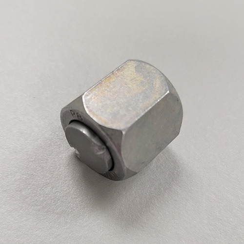 A metal nut with a nylon insert lock feature, commonly known as a nylock nut, viewed from the side showing the insert.